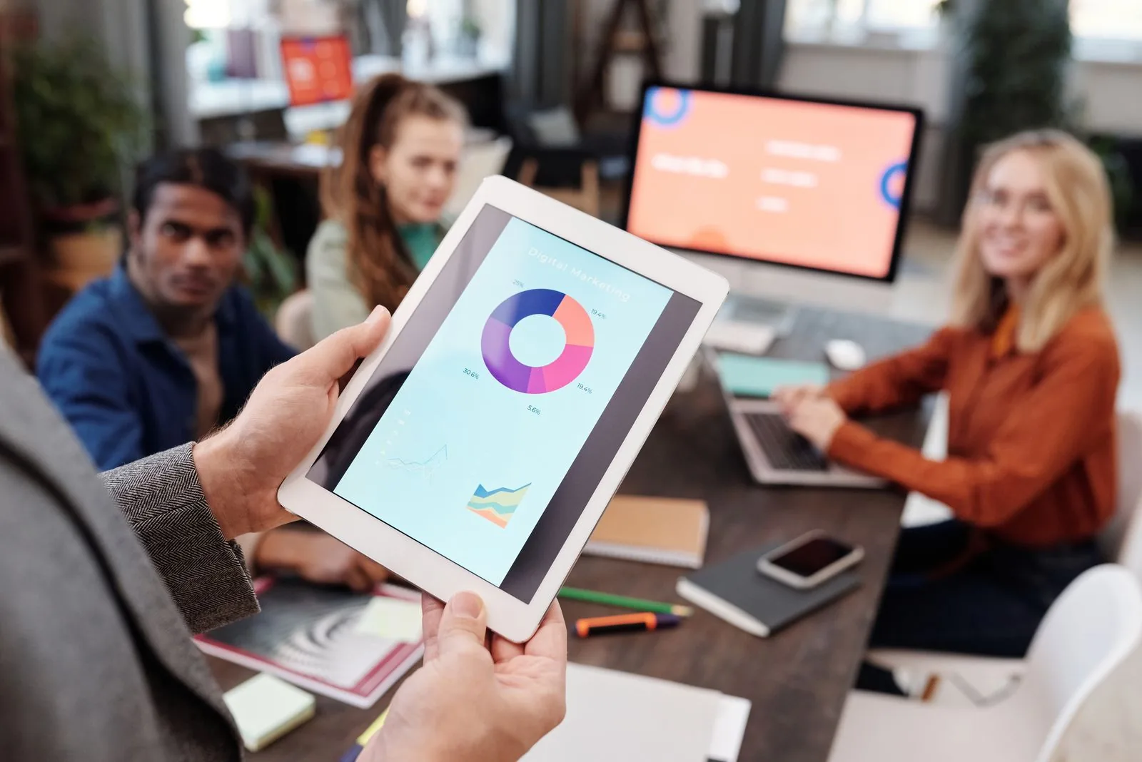 Marketing team reviewing campaign performance on a digital analytics tablet